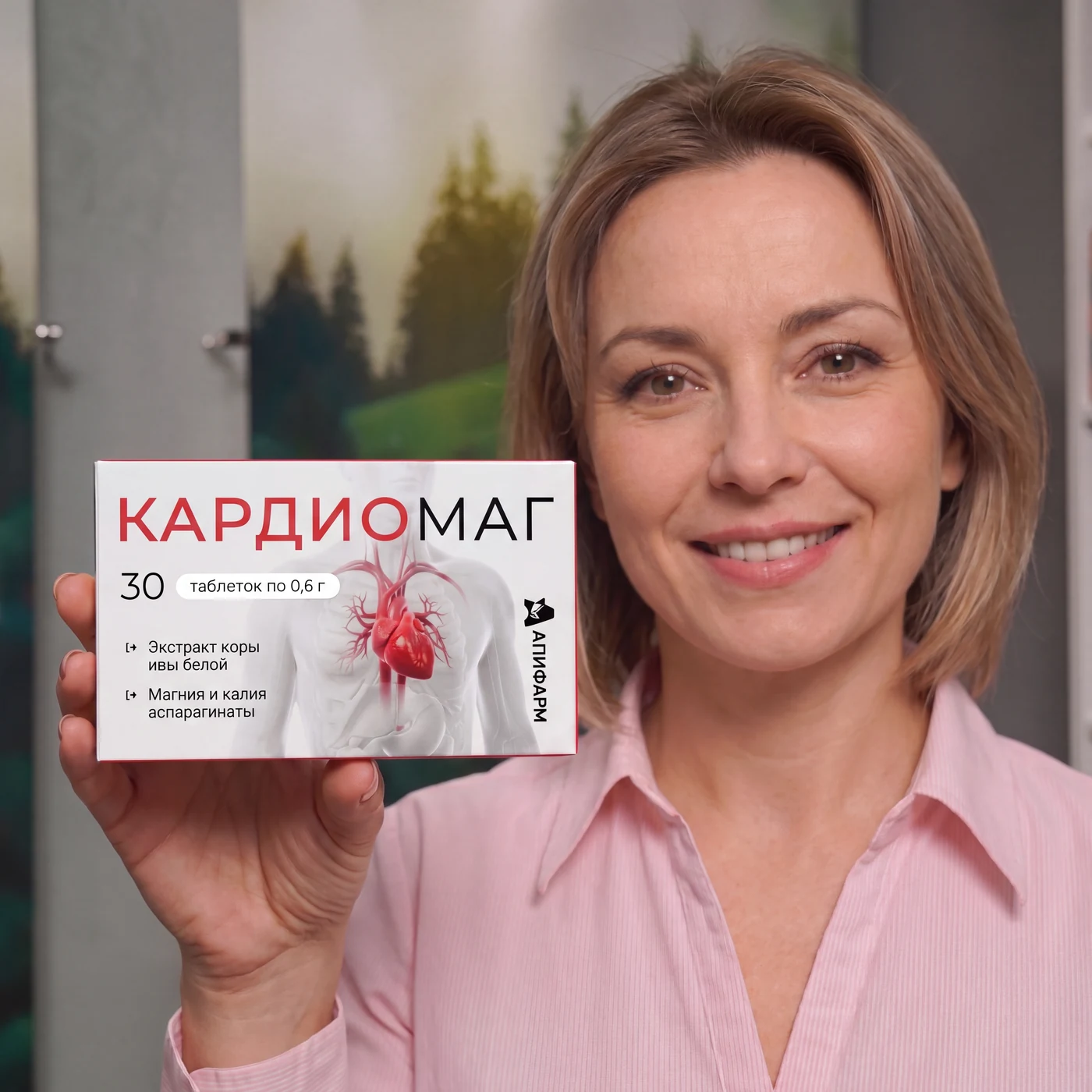 Улыбающаяся женщина держит упаковку Кардиомаг от Апифарм